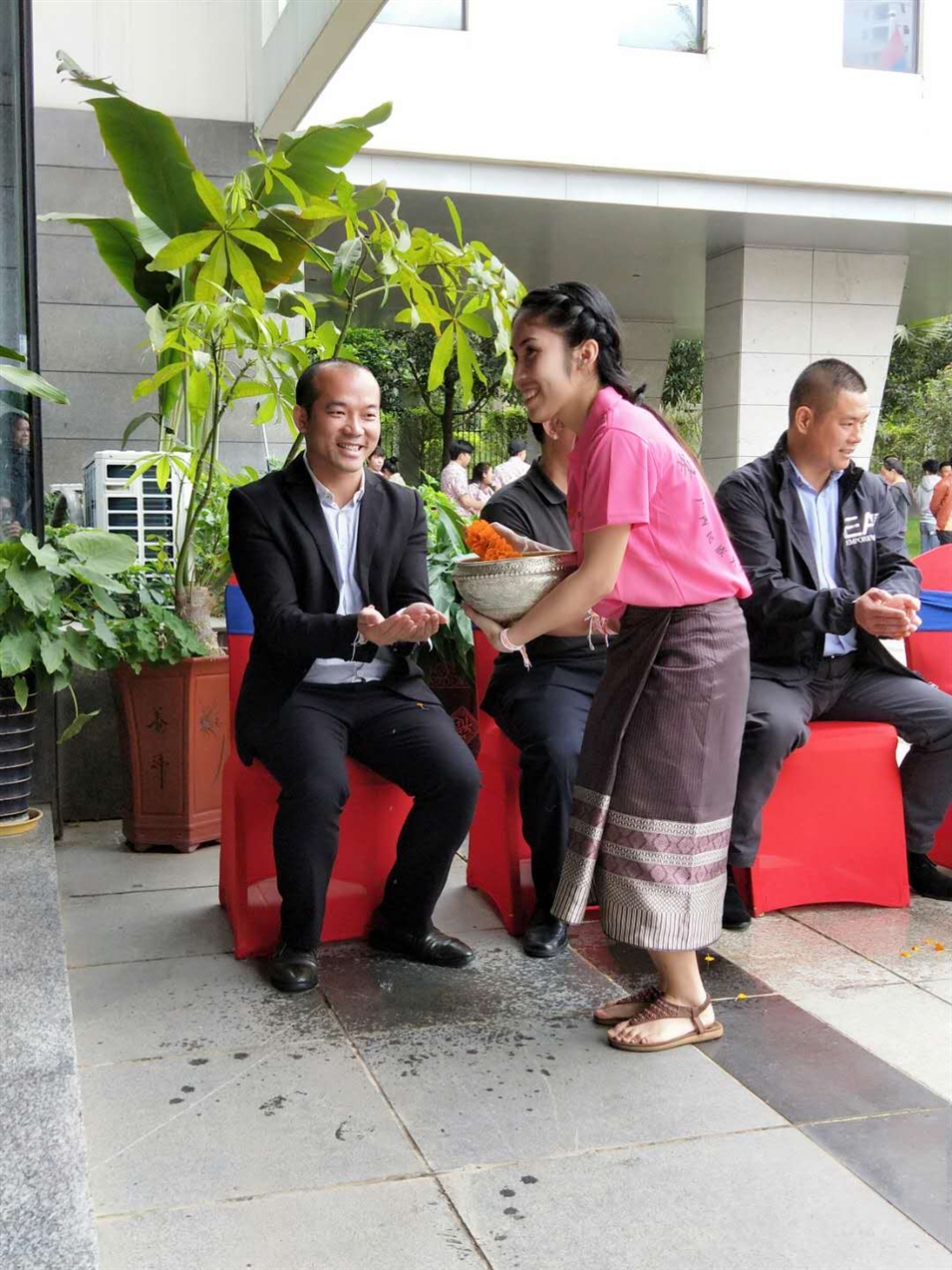 老撾駐廣西留學(xué)生代表將浸有花瓣的香水灑客人的手上，表示對(duì)嘉賓的美好祝福（圖一）